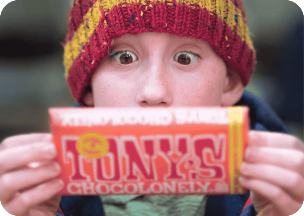 Boy with a hat holding a chocolate bar
